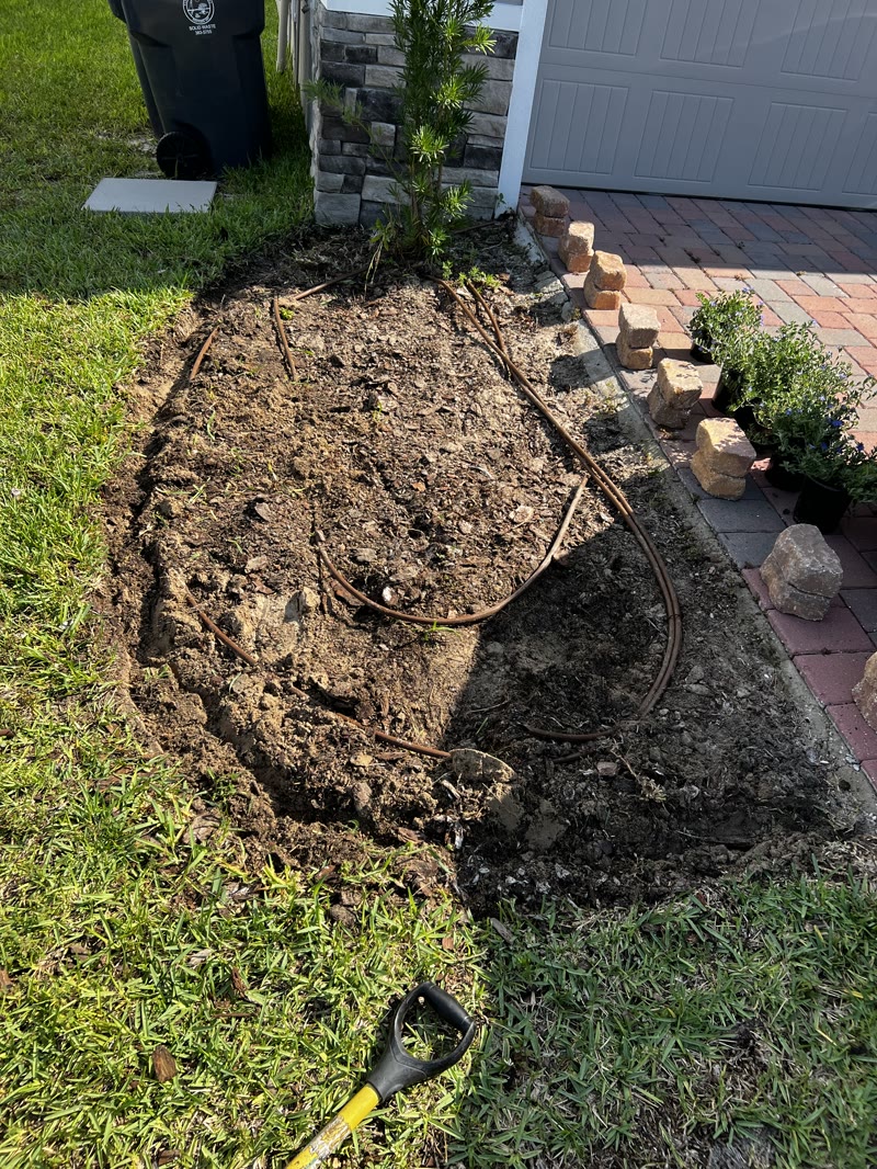 Irrigation line dug out and repaired in a planting bed on a North Brevard property by Big Mike's
