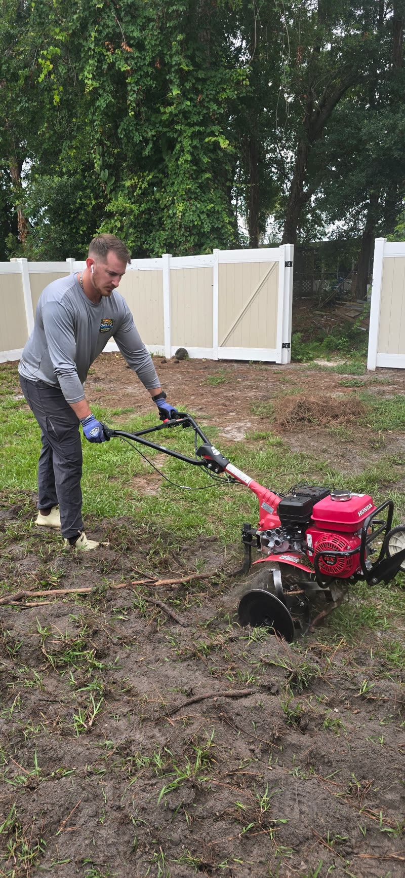 Crew running a rototiller to prep bare ground on a large Mims, Florida property